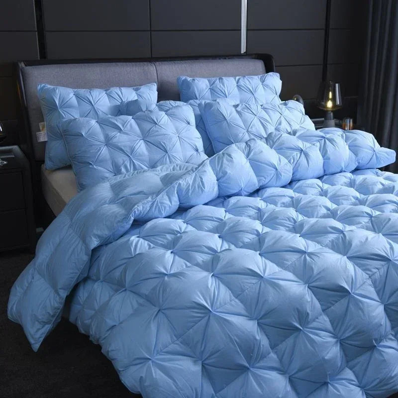 Alira goose down duvet in blue with matching quilted pillows in a dark modern bedroom
