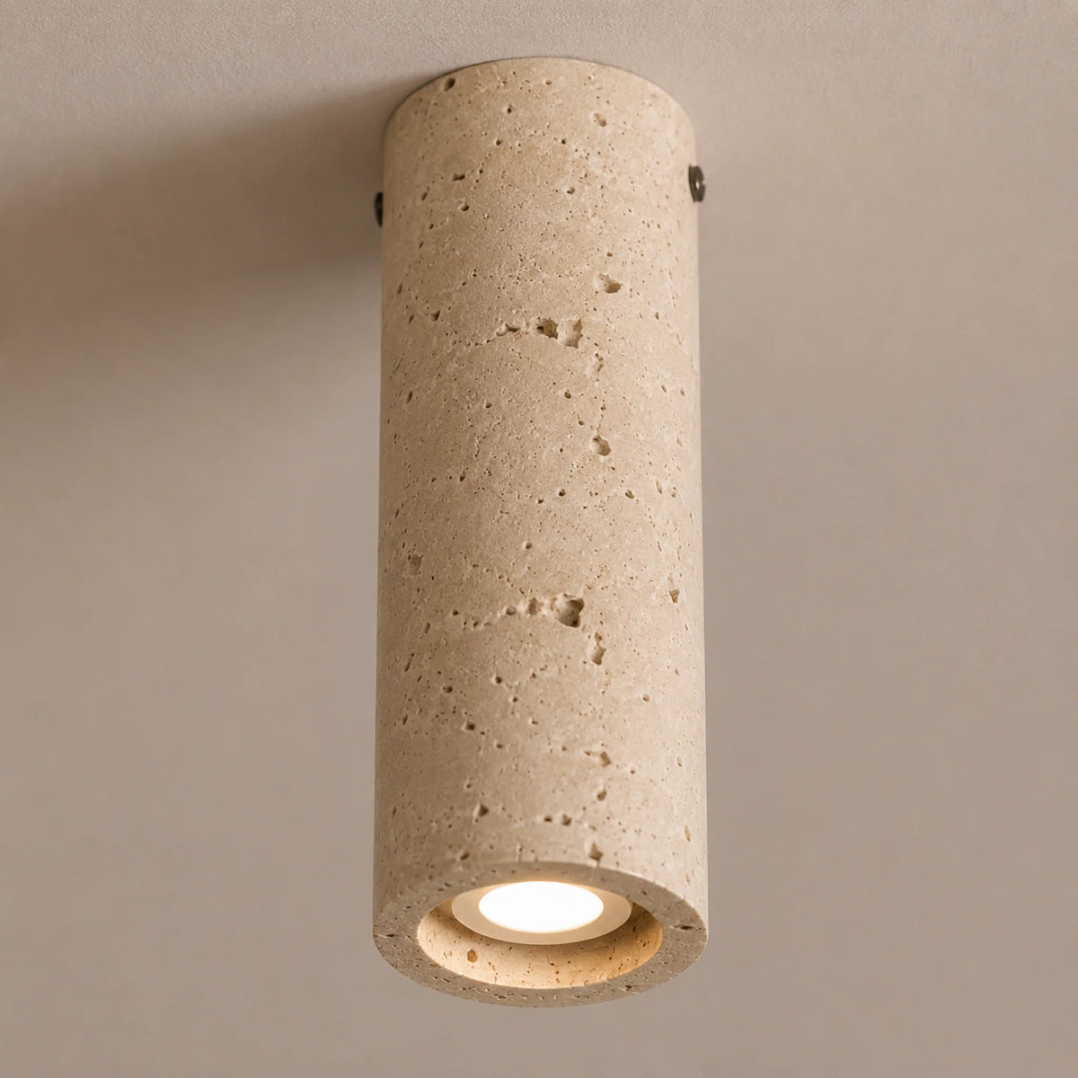 Amon travertine ceiling light close up of the natural pitted stone and recessed downlight