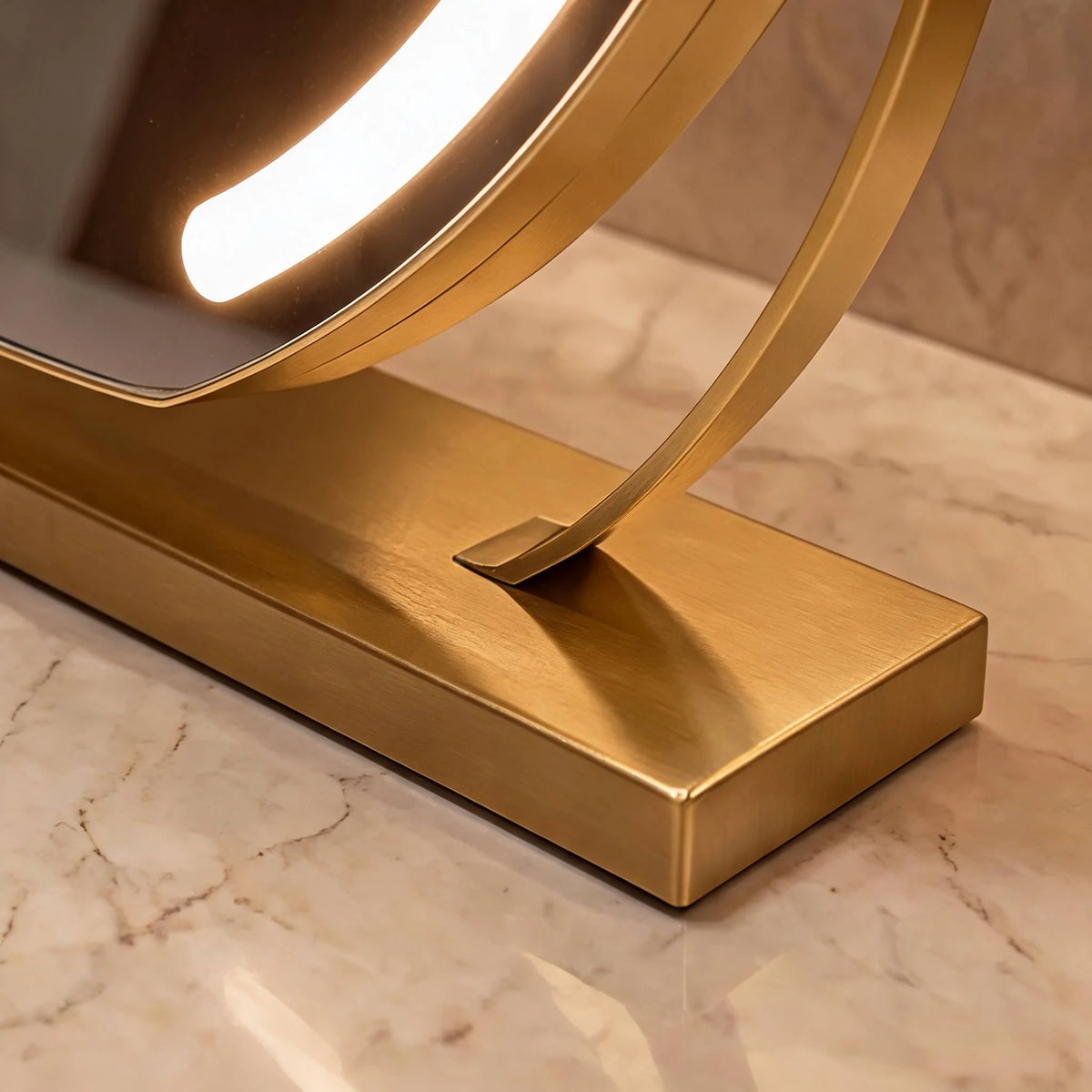 Close-up detail of the Aspen vanity mirror gold metal base and swivel arm