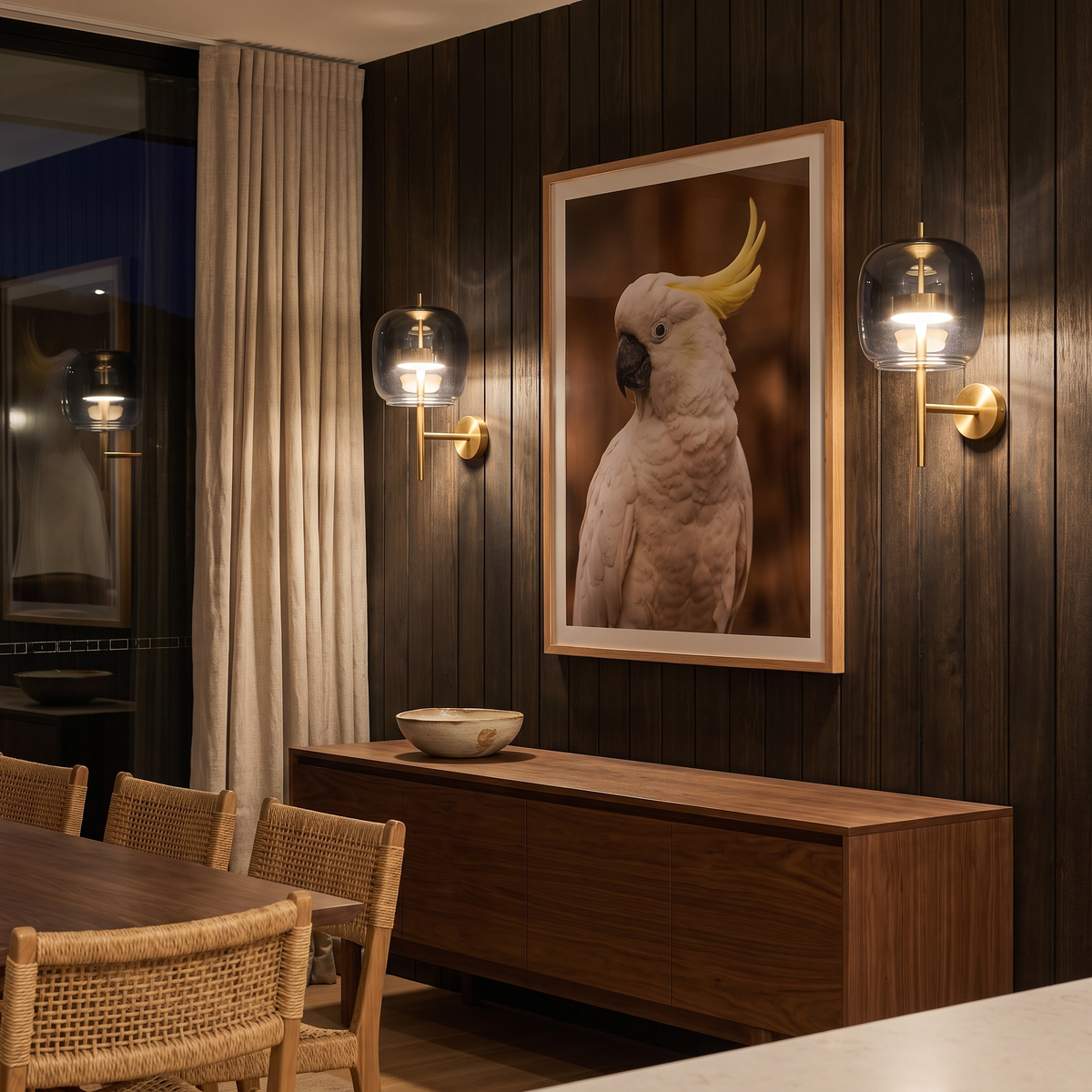 Aura smoked glass wall sconce in smoke grey glass flanking artwork in a coastal dining room at night