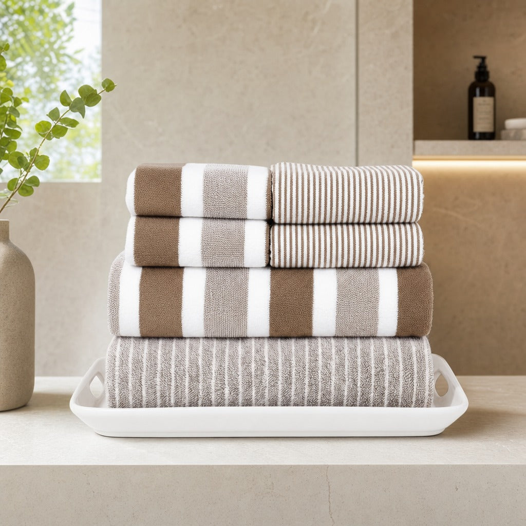Aurelia 8-piece microfibre towel set in brown stacked on a white tray in a bathroom