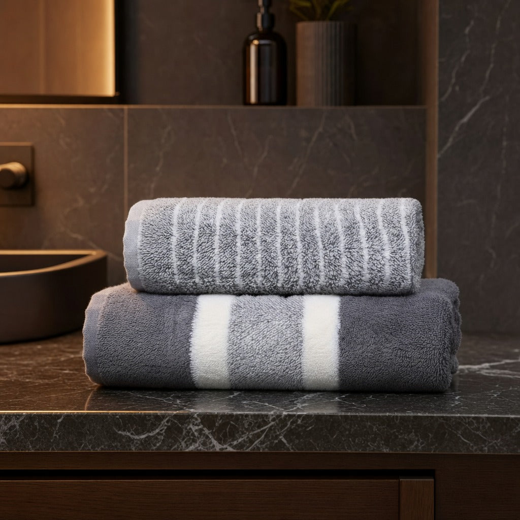 Aurelia microfibre bath towel set in grey stacked on a dark marble bathroom vanity