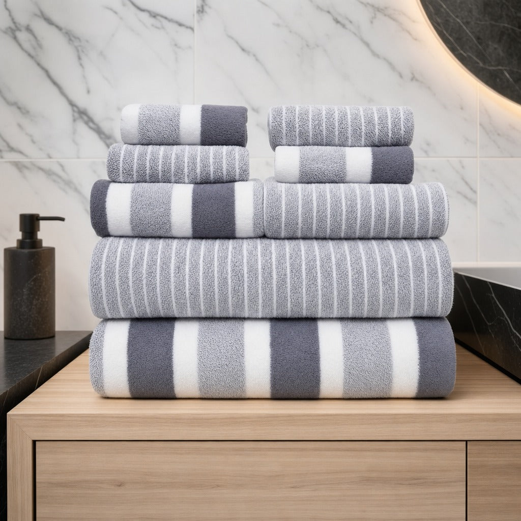 Aurelia 8-piece microfibre towel set in grey folded on an oak vanity against white marble
