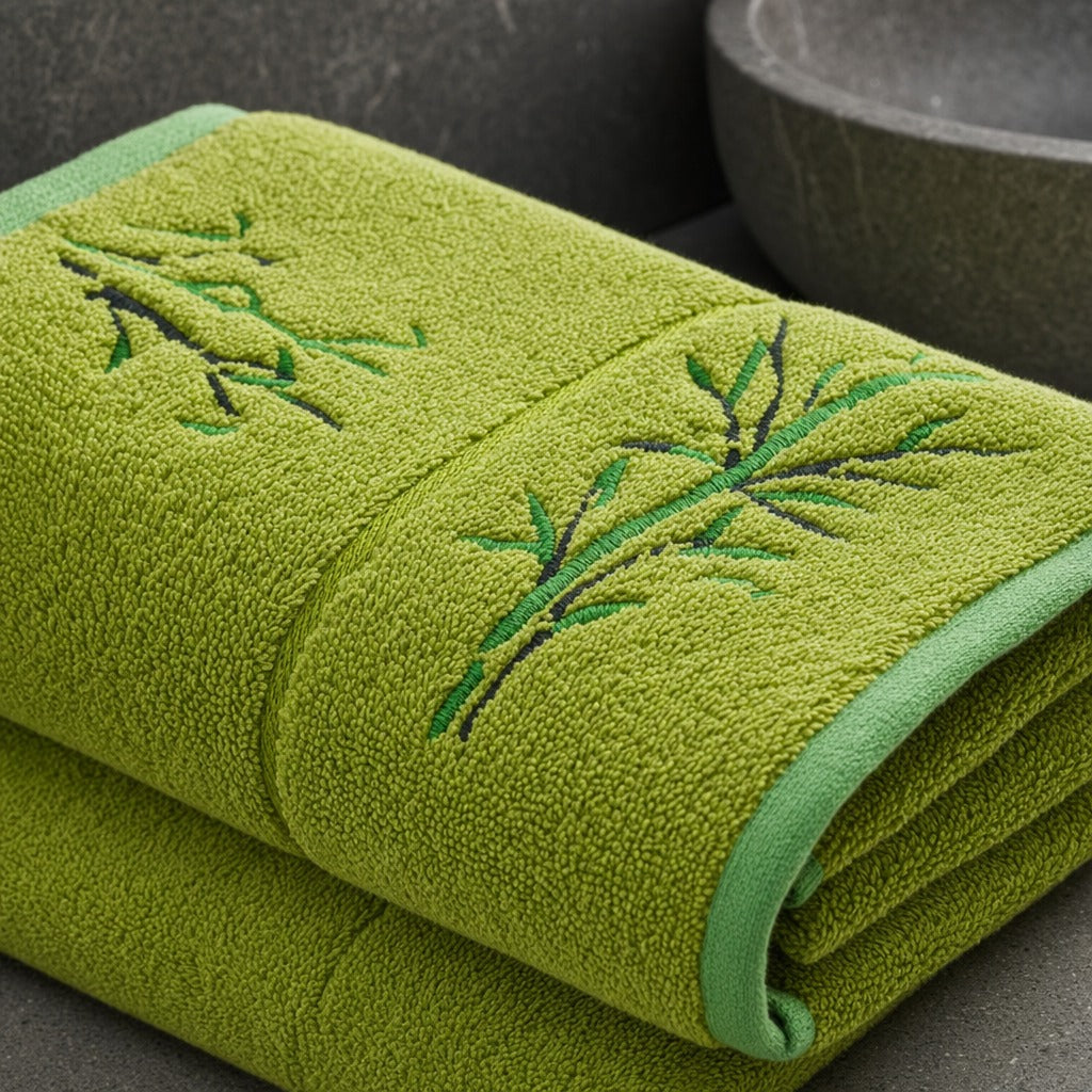 Close-up of the green bamboo towel showing its embroidered bamboo leaf motif and trim