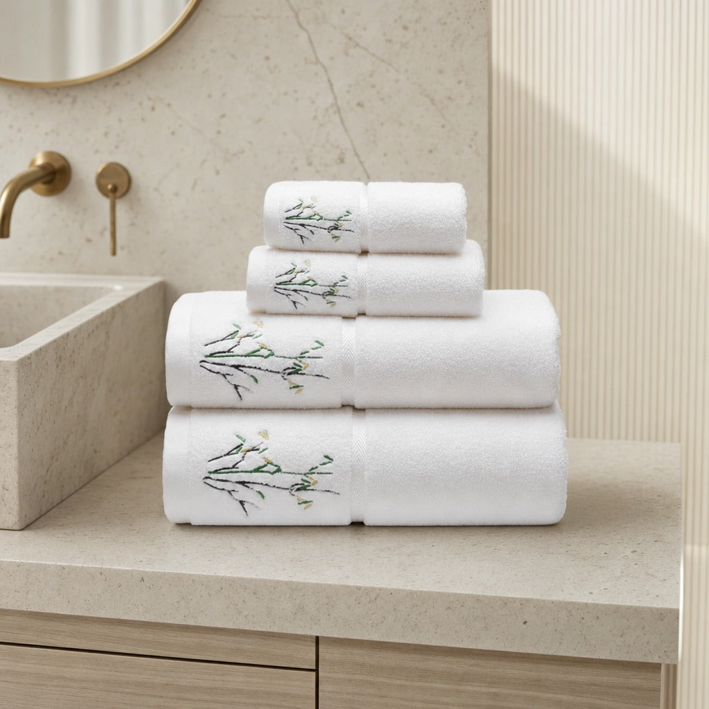 Bamboo face and bath towel set in white with embroidered bamboo on a marble vanity