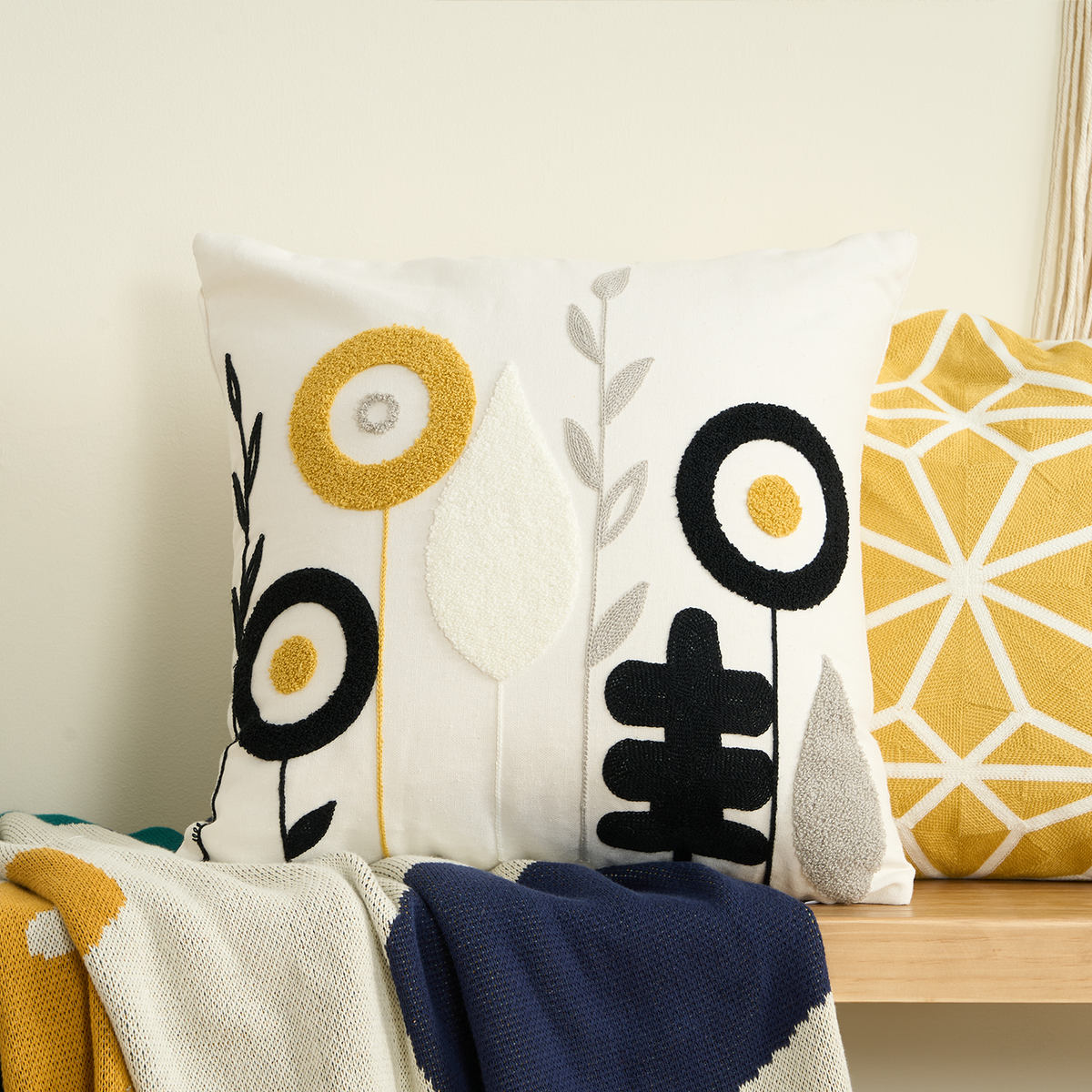 Blossoms ivory floral tufted cushion cover on a bench with a mustard cushion and knit throws