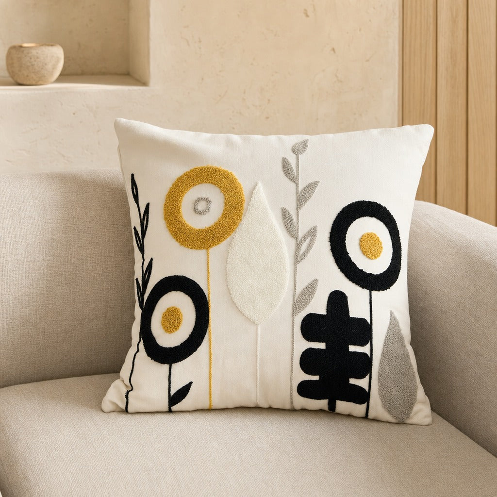 Blossoms ivory tufted cushion cover with mustard and black flowers on a soft grey sofa