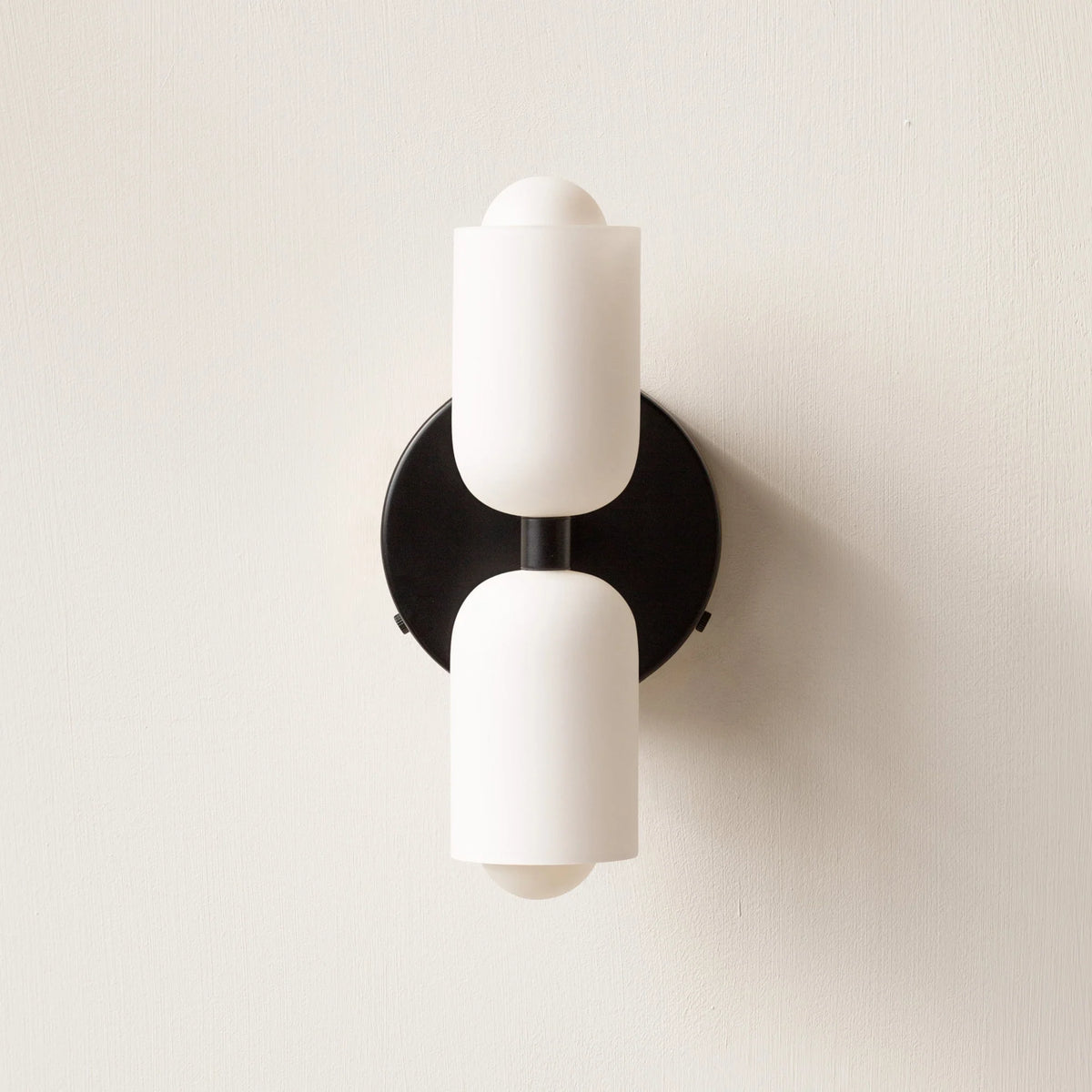 Boni up and down wall light with a black wall plate and two white scalloped opal shades