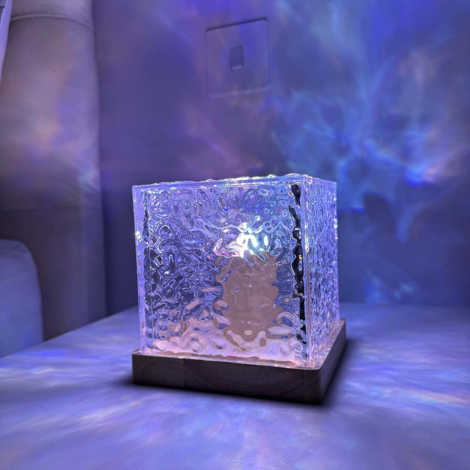Borealis Cube lamp illuminated on a bedside table at night