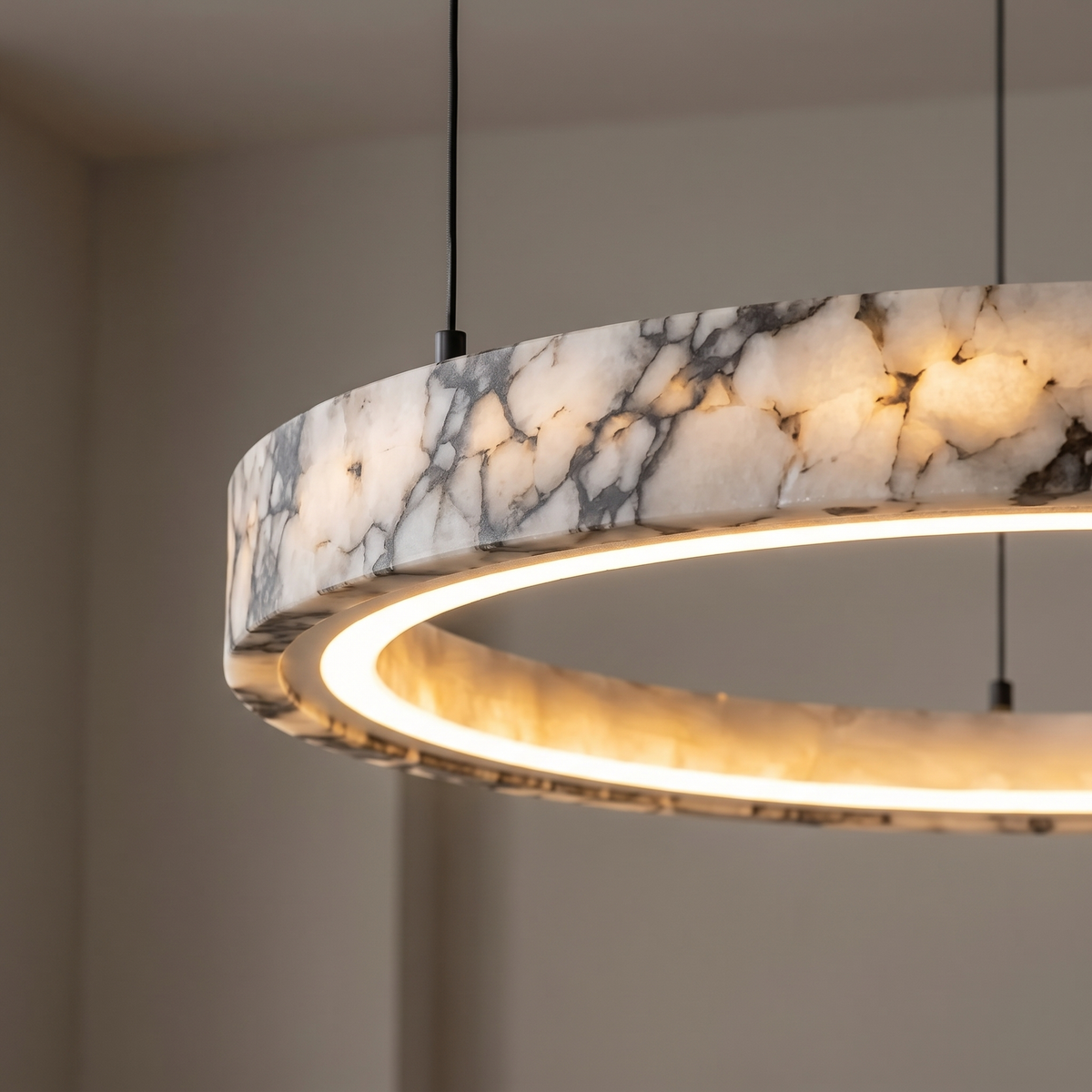 Close-up of a Byron chandelier natural marble ring showing its veining and warm LED glow