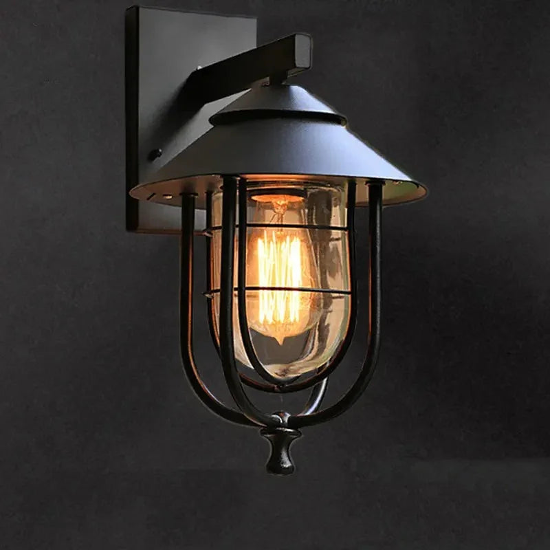 Close-up of the Cala Outdoor Wall Light's iron frame and glass shade
