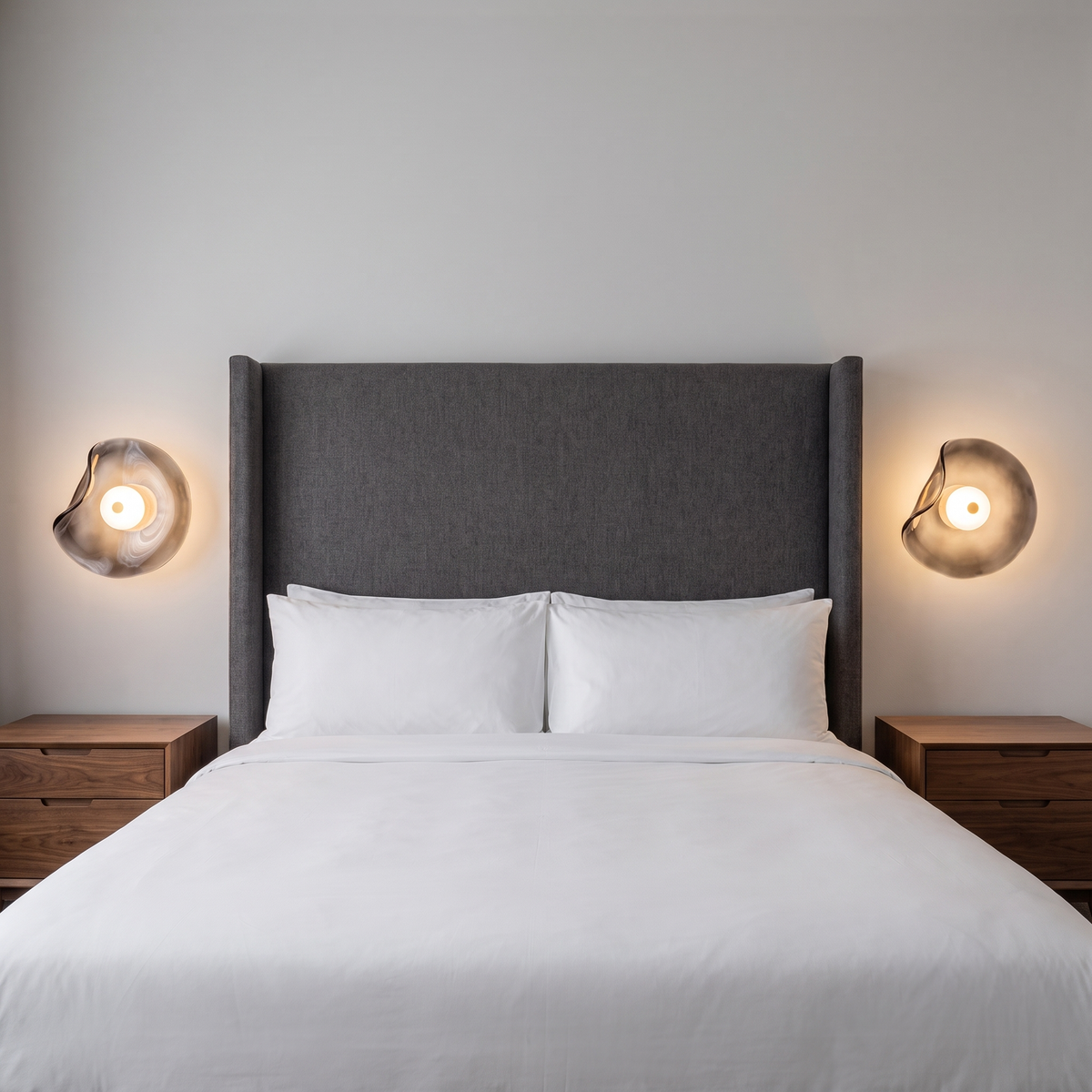 Cami glass wall sconce in smoke grey glass either side of a bed in a luxury hotel room