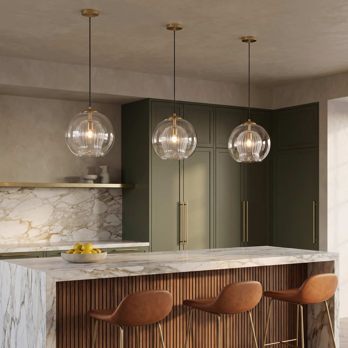 Three Capri clear glass pendants over a marble waterfall island in an olive green designer kitchen
