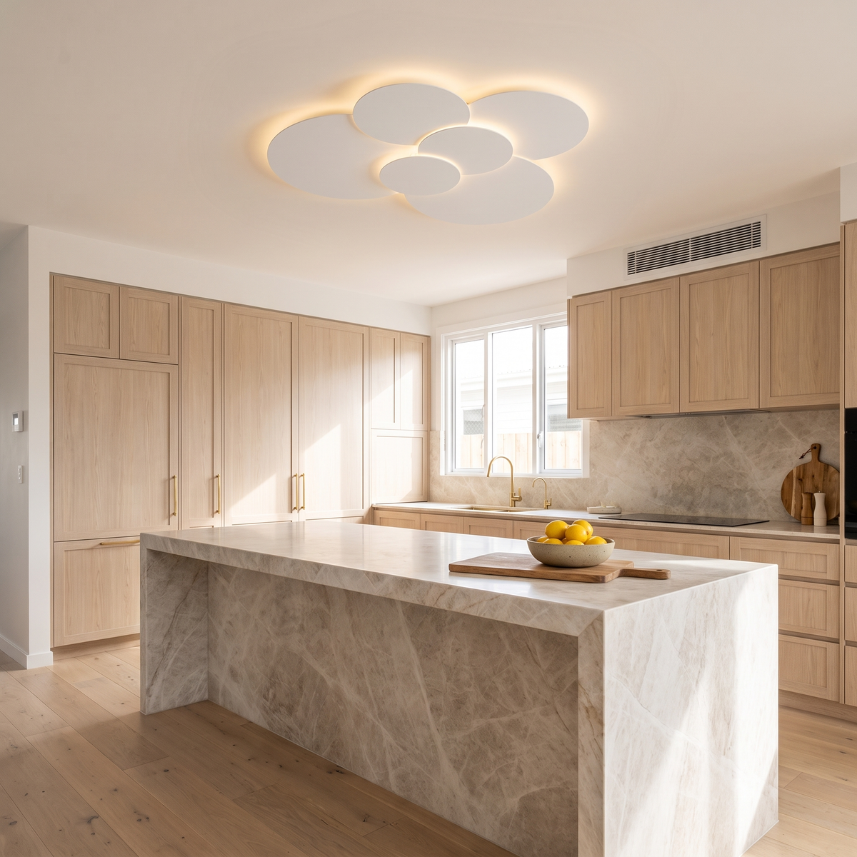 Cloey 80 cm six-disc LED ceiling light in a coastal Australian kitchen with a marble island and pale oak cabinetry