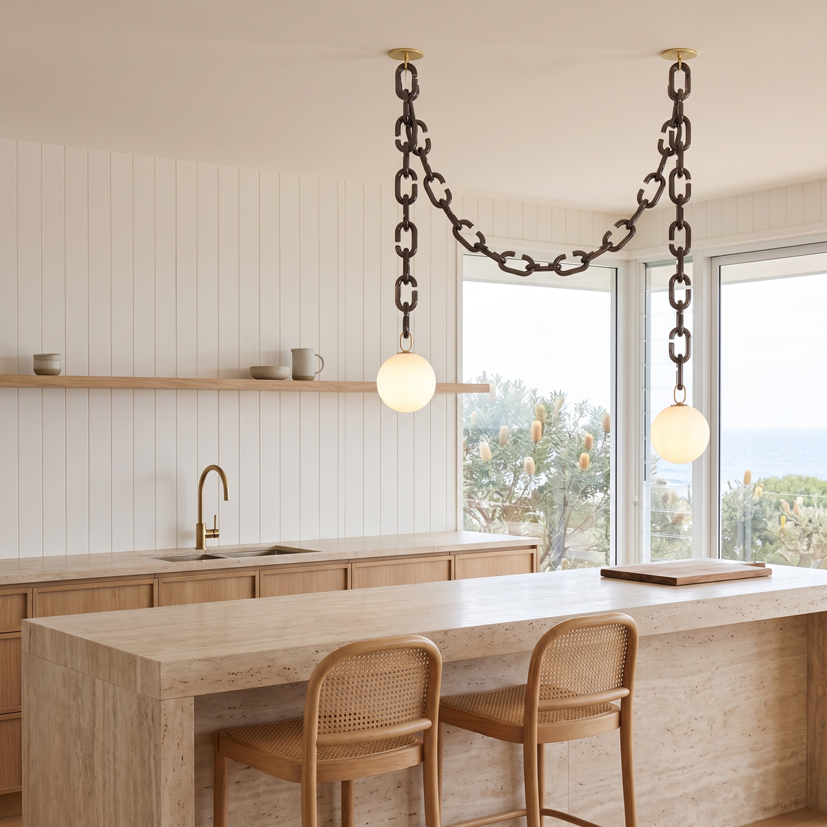 Clove 2-head glass chain pendant light with white globes over a travertine kitchen island