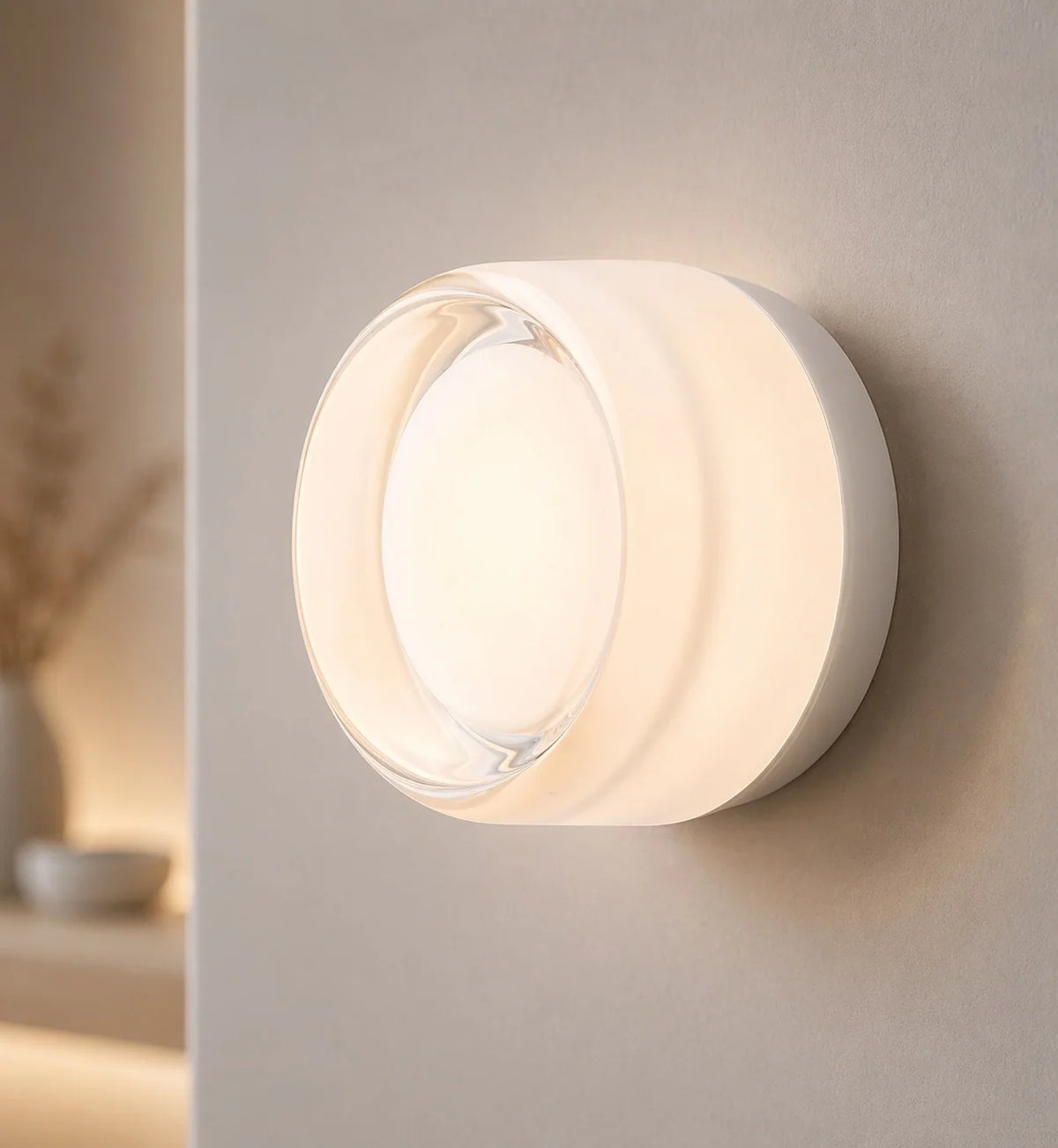 Comu white Circle glass sensor wall light glowing softly on a pale wall