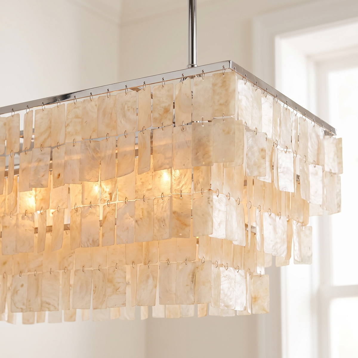 Close detail of the Coolum chandelier's chrome frame and stepped rows of capiz shell tiles