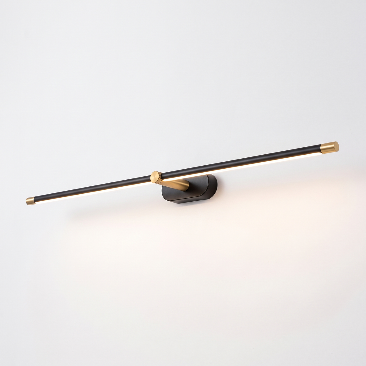 Debi black wall lamp with gold end caps and knuckle on a plain white background
