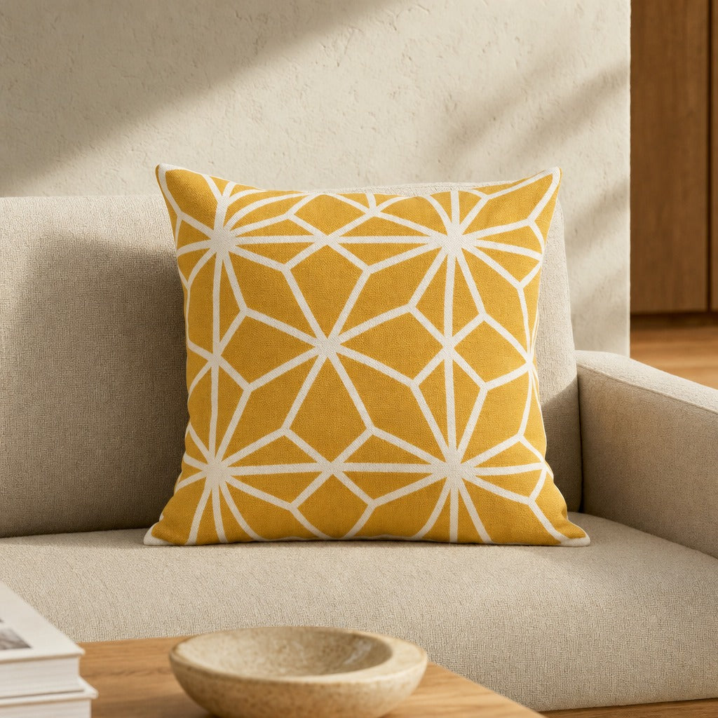 Diamond Tiles golden mustard cushion cover on a cream armchair beside an oak coffee table