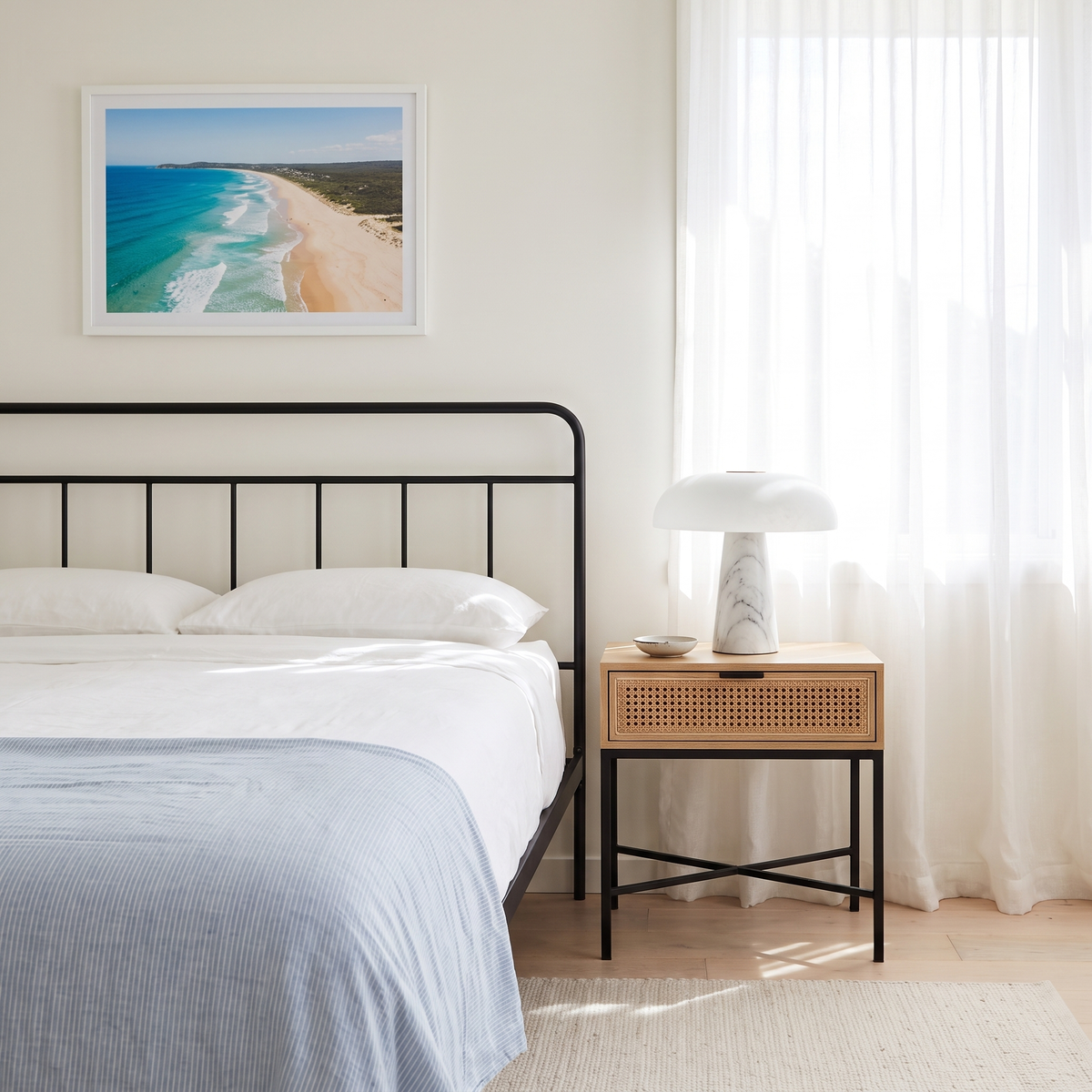 Dover Table Lamp with Marble Base on a rattan bedside table in a bright coastal bedroom