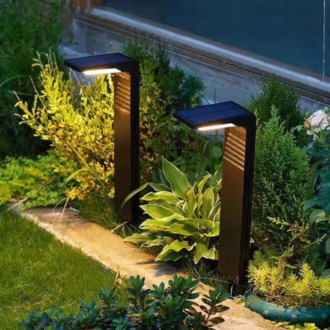 Ecca Solar Garden Lamp illuminated at dusk among flower beds