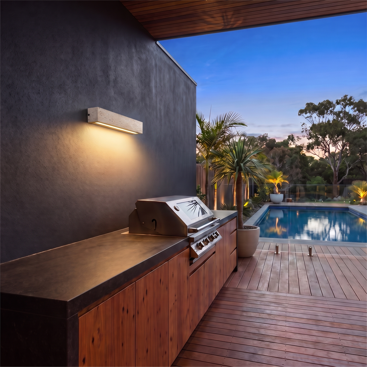 Large Elin travertine outdoor wall sconce above an outdoor BBQ kitchen bench