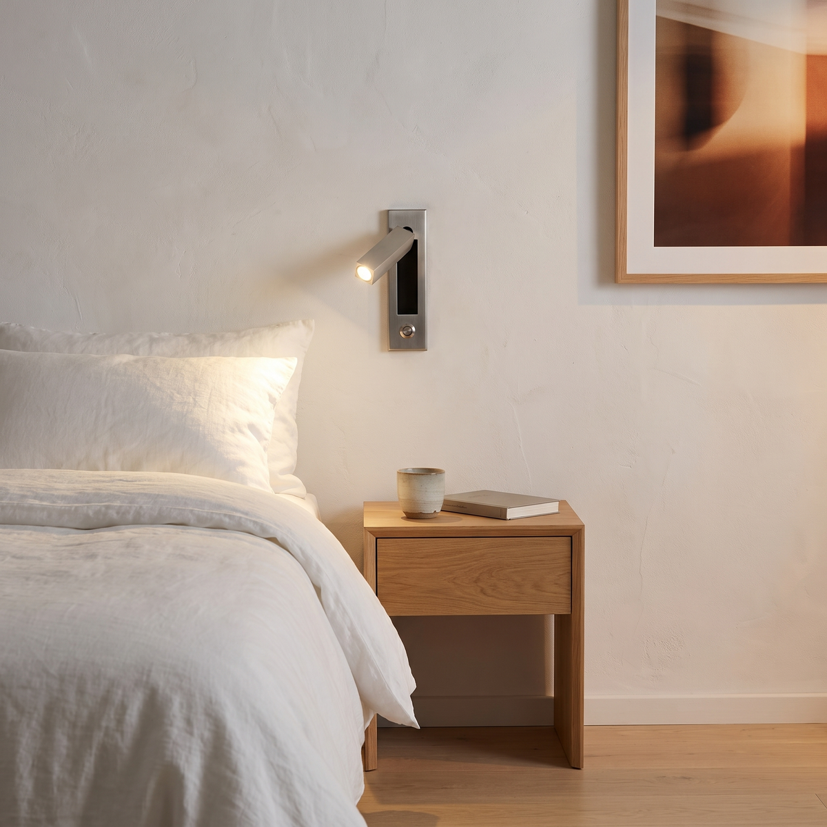 Espy LED reading wall light in square nickel beside the bed in a Scandinavian bedroom