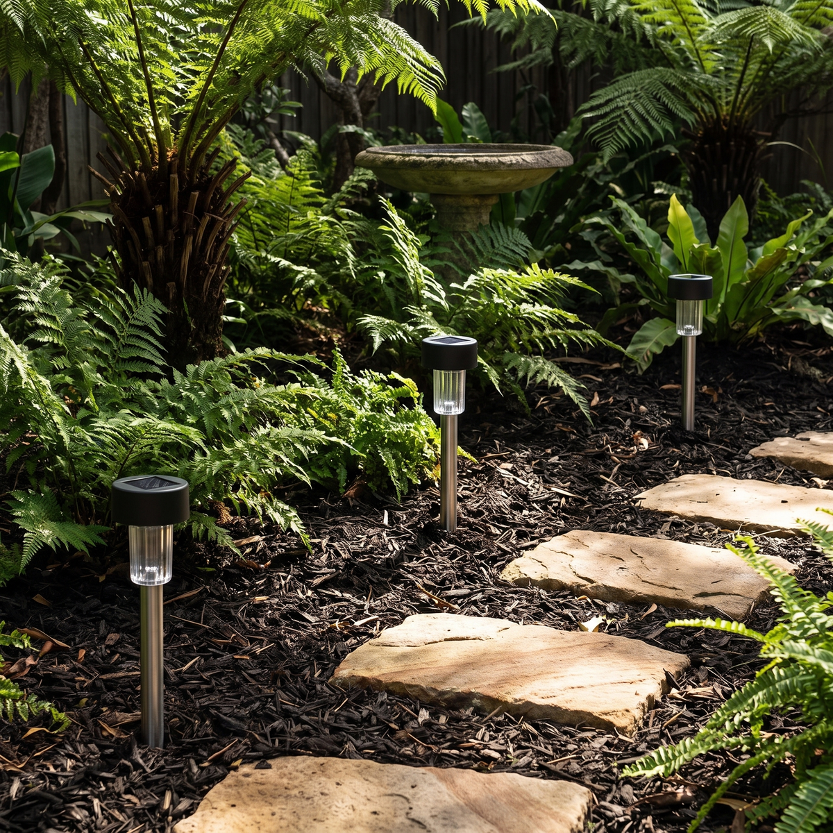 Fairlight solar path lights beside sandstone stepping stones in a fern garden