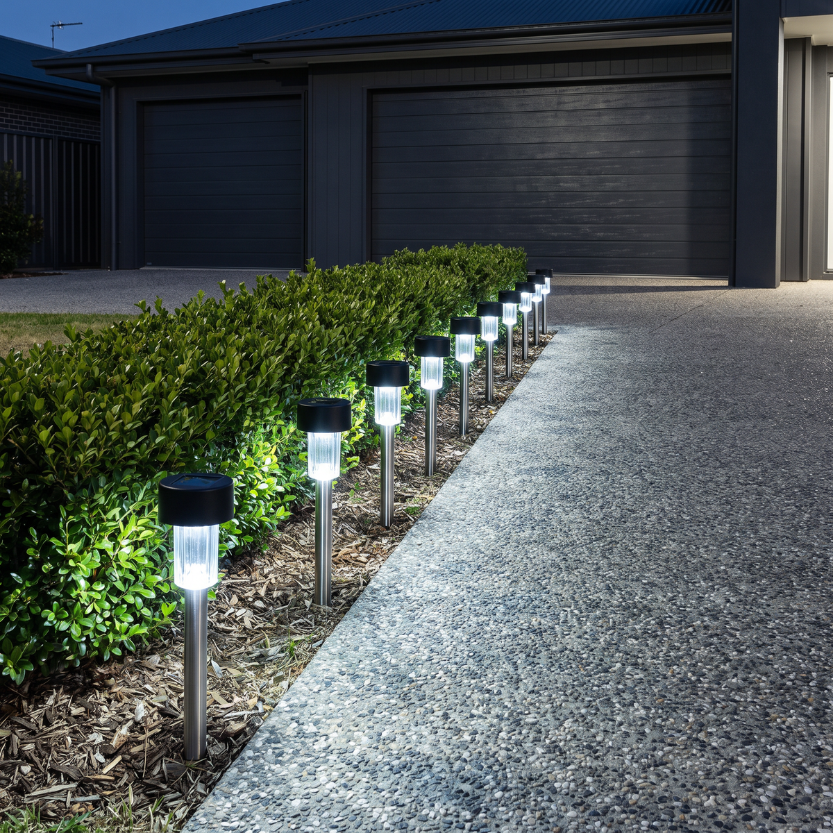 Fairlight solar pathway lights in cool white lining a concrete driveway