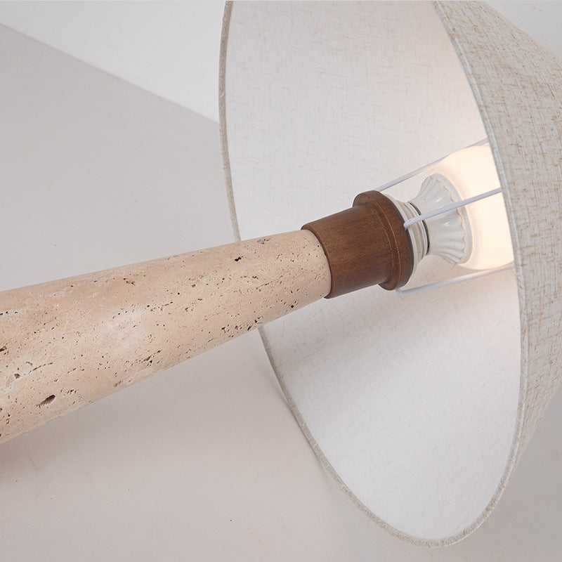 Fingal travertine table lamp lit showing the warm glow through the fabric shade