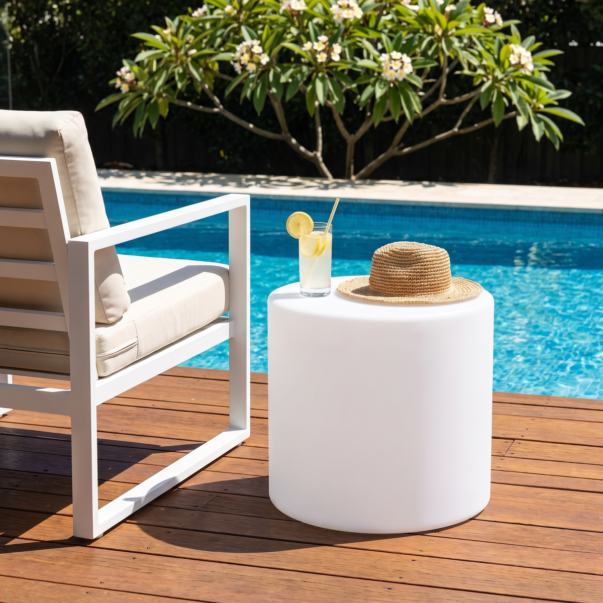 Geri white round outdoor side table by a pool deck in daytime