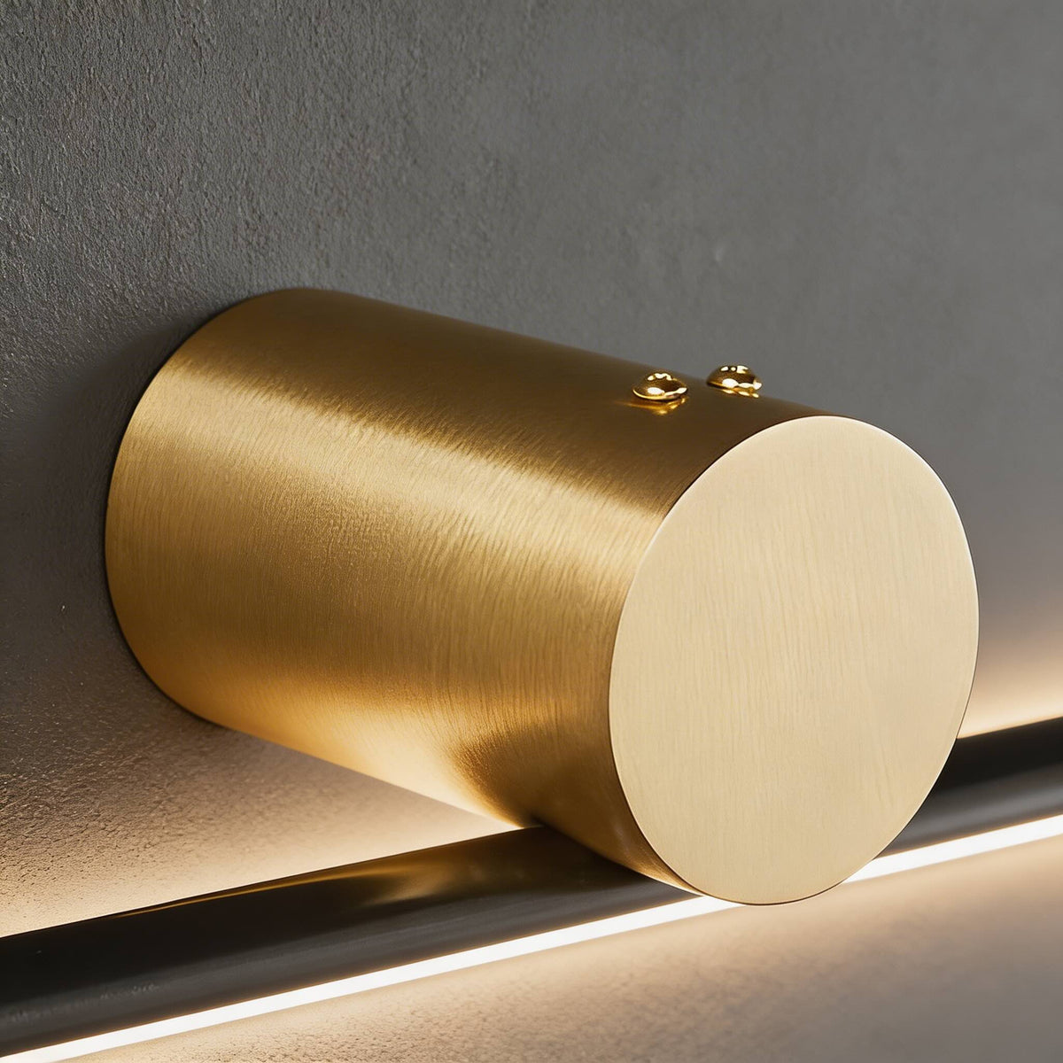Close-up of the brushed gold cylinder mount on the Hartog vanity light bar