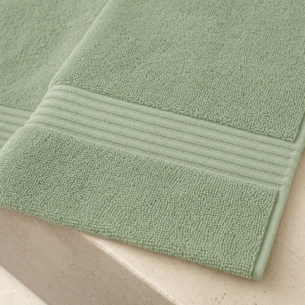 Haven Turkish cotton towel folded on marble, showing the striped dobby border up close