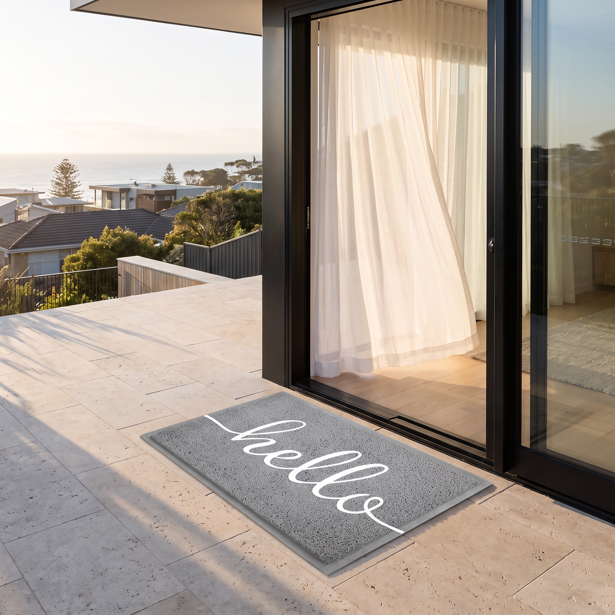 Hello welcome doormat in grey on travertine pavers at a beach house terrace door