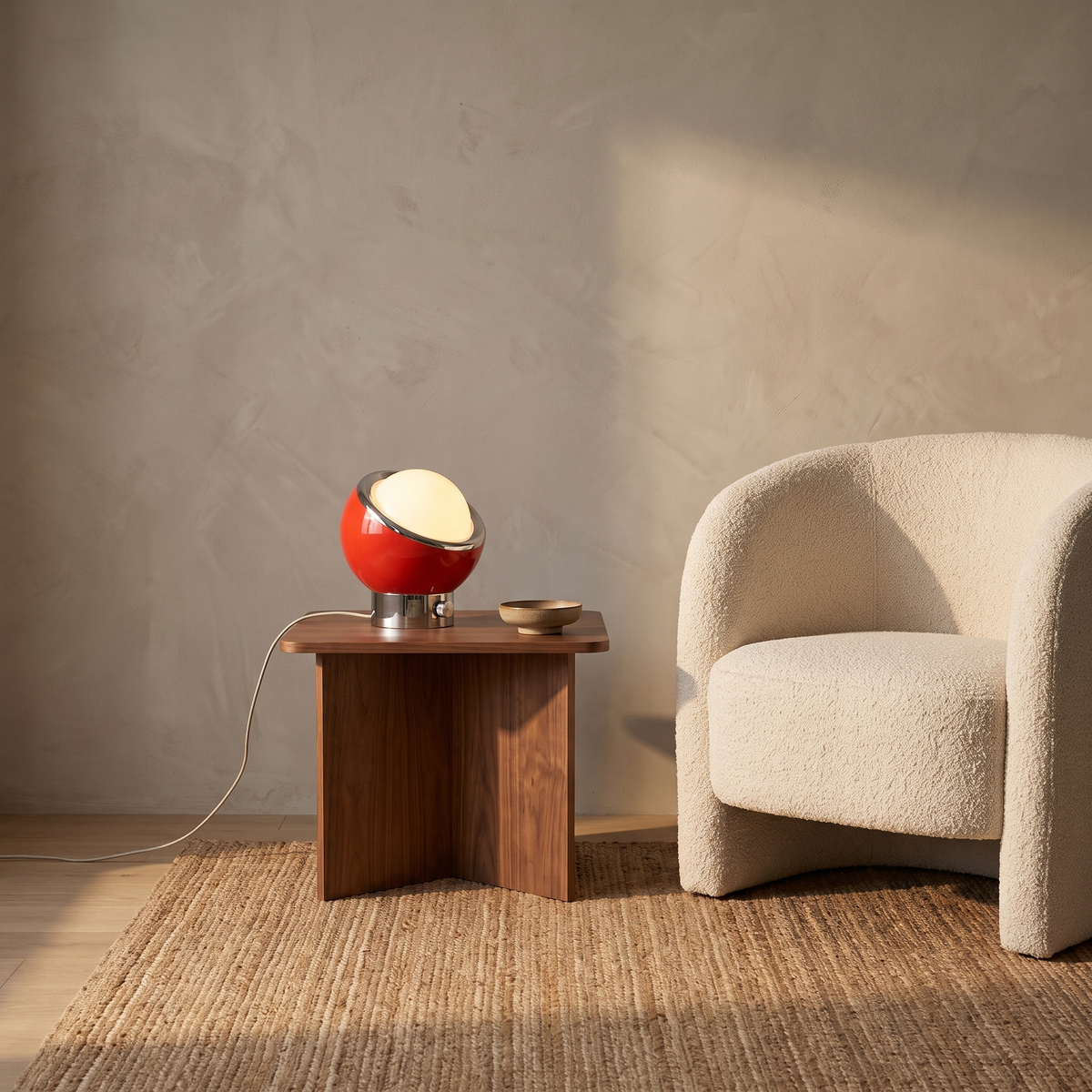 Jayla Bauhaus table lamp in red glowing on a walnut side table in a Scandinavian living room