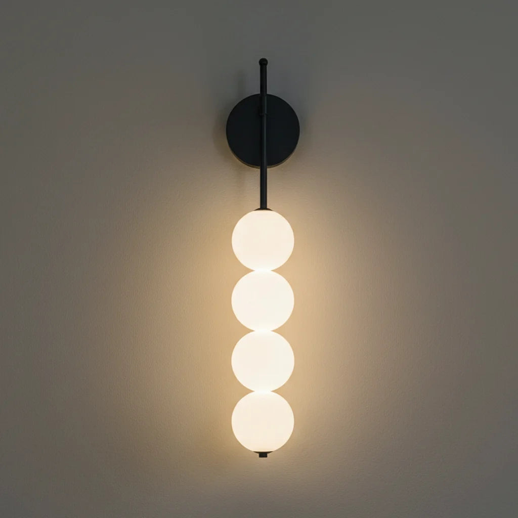 Jilli opal glass wall sconce in black with four stacked opal globes lit