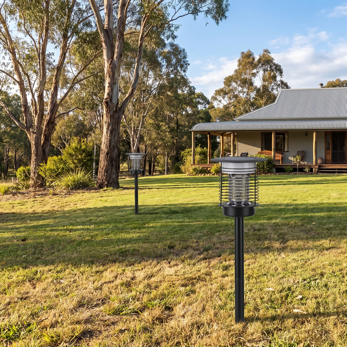 Two Juli Solar Bug Zapper Pathway Lights in black on an acreage lawn with gum trees and a verandah farmhouse