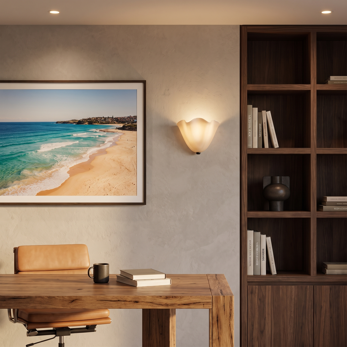 Kira artistic wall sconce in beige glass lit beside walnut shelving in a home study
