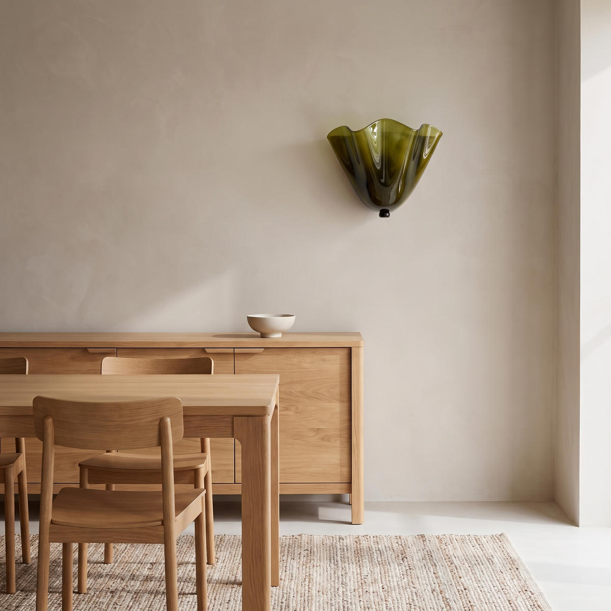Kira artistic wall sconce in green glass above an oak sideboard in a Scandinavian dining room