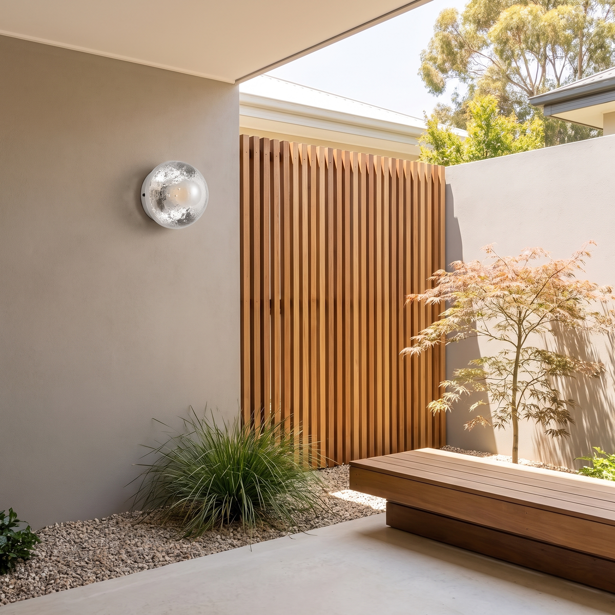 Larry glass dome wall light on a greige rendered courtyard wall beside a timber batten screen