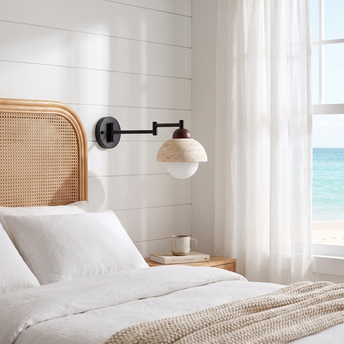 Lido travertine swing arm wall lamp in a beach house bedroom