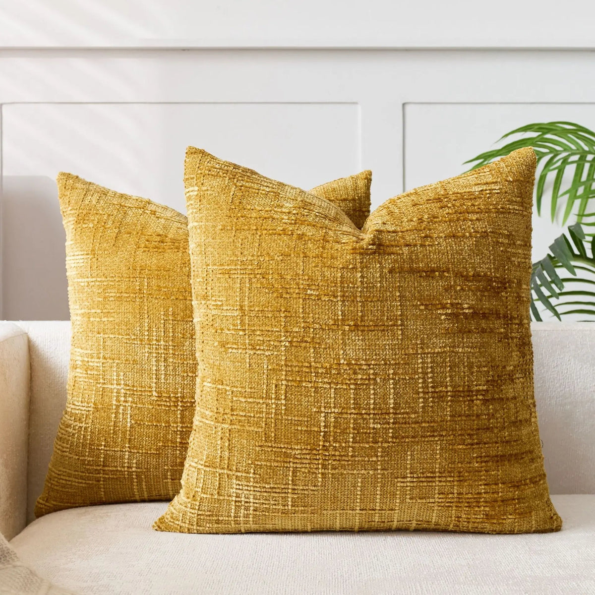 Lucina chenille throw pillows in yellow on a white sofa in a panelled living room