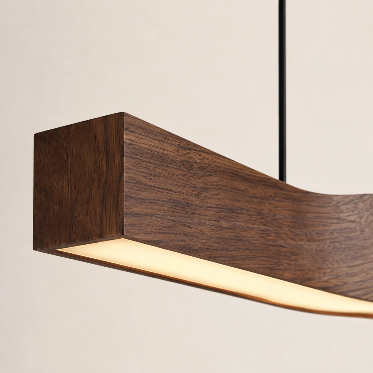 Close-up of the Minna linear pendant's square walnut wood-grain end and glowing LED diffuser