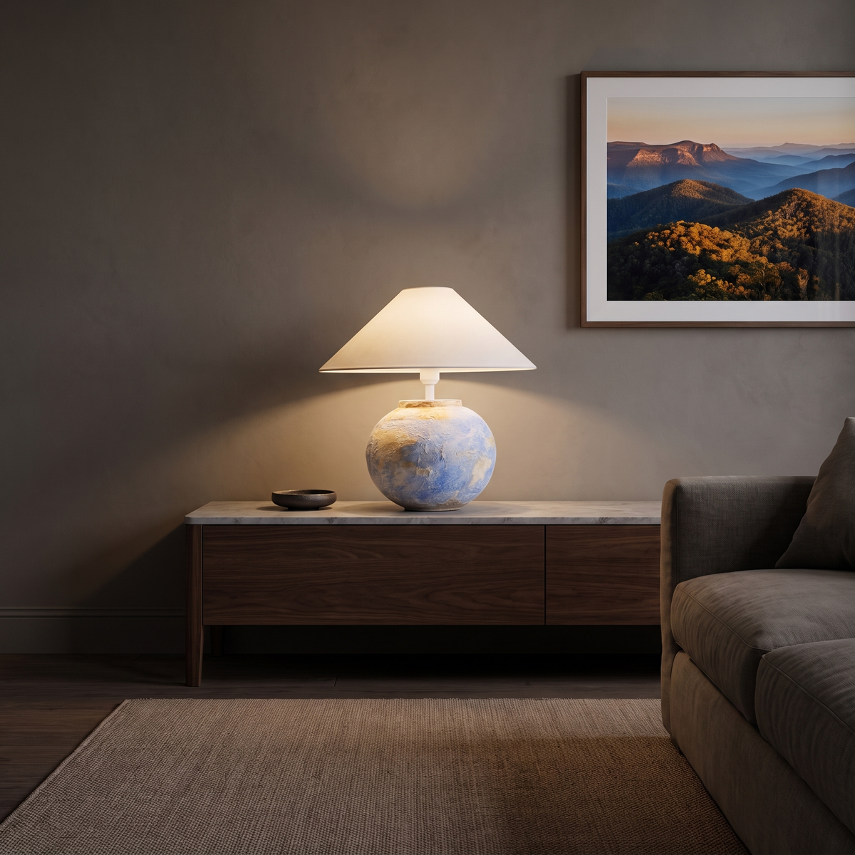 Monique Table Lamp with Watercolor on a marble-topped walnut console in a warm living room at dusk