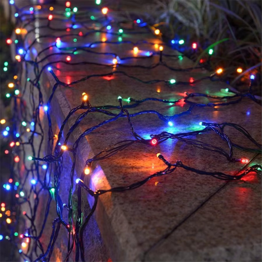 Mulligan multicolour LED fairy lights draped over a garden wall at night