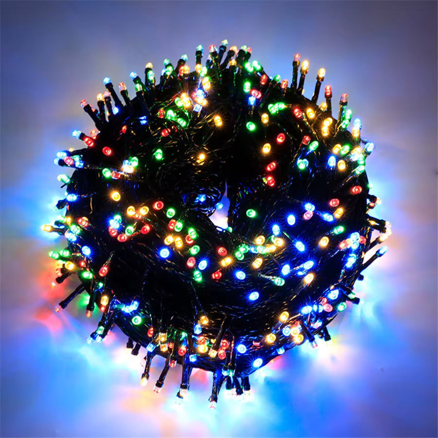Mulligan multicolour LED fairy lights lit up in a ring on dark green wire
