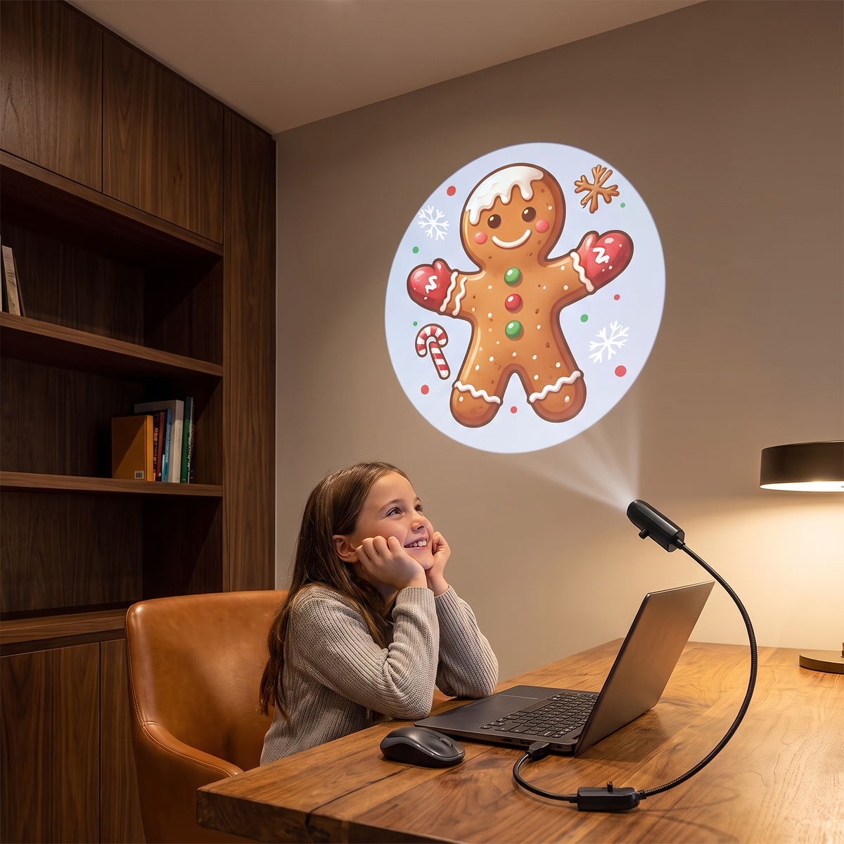 Noelle Christmas projector light plugged into a laptop projecting a gingerbread man