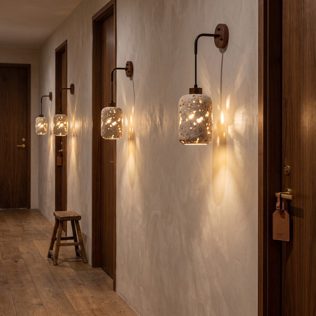 Nora travertine wall sconce in a hotel corridor