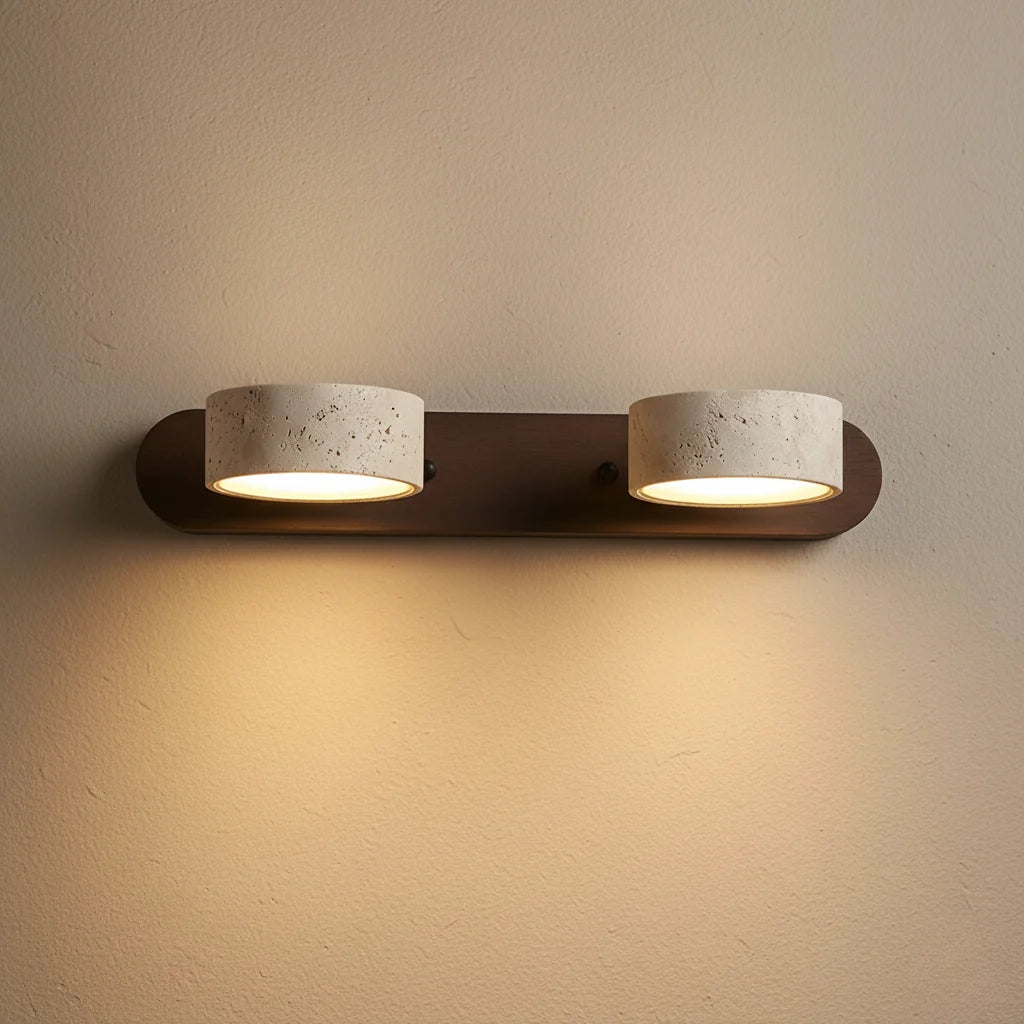 Notu travertine wall light with a dark wood bar and two travertine spotlights lit on the wall