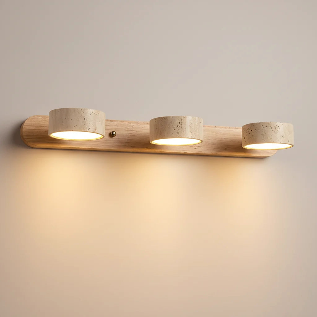 Notu travertine wall light with a light wood bar and three travertine spotlights lit on the wall